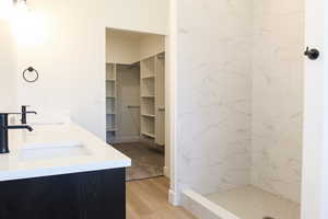 Bathroom featuring vanity, wood-type flooring, and tiled shower