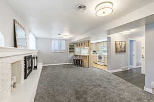 Unfurnished living room featuring a fireplace and carpet flooring