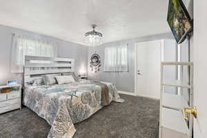 Carpeted bedroom with a chandelier