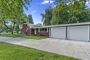 View of front of property featuring a garage and a front yard