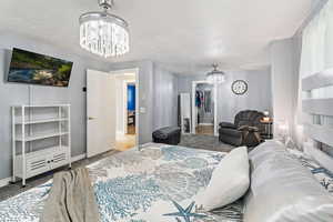 Bedroom with hardwood / wood-style floors and a chandelier