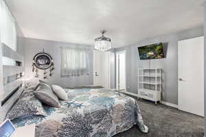 Bedroom with carpet and a notable chandelier