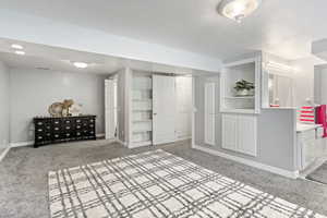 Unfurnished bedroom with a closet, a textured ceiling, and light colored carpet