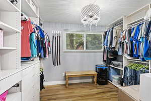 Spacious closet featuring an inviting chandelier and light hardwood / wood-style floors