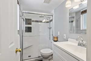 Bathroom featuring vanity, toilet, and walk in shower