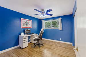 Office with light hardwood / wood-style flooring and ceiling fan