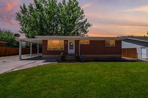 View of front of house with a yard and a carport