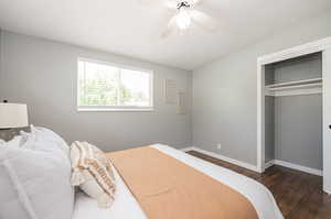 Bedroom featuring dark wood-type flooring, a closet, and ceiling fan