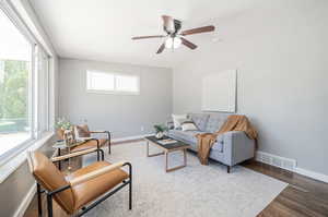 Living room with ceiling fan and hardwood / wood-style floors