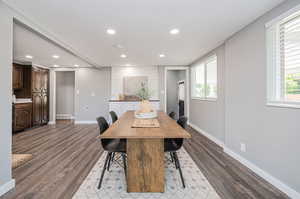 Dining area with dark wood-type flooring