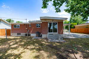 Back of property with cooling unit and a patio