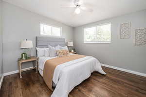 Bedroom featuring dark hardwood / wood-style flooring, multiple windows, and ceiling fan