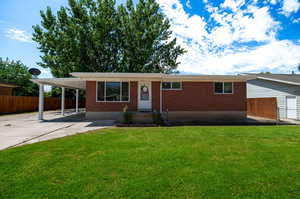 View of front of house with a carport and a front yard