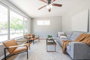 Living room with lofted ceiling, light hardwood / wood-style floors, and ceiling fan