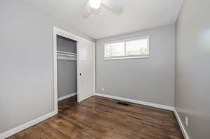 Unfurnished bedroom with a closet, ceiling fan, and dark hardwood / wood-style floors