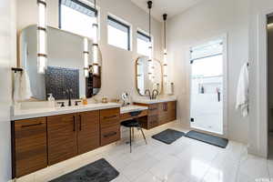 Bathroom with tile patterned floors, tiled shower, and a healthy amount of sunlight