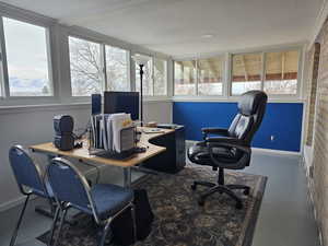 Home office featuring brick wall and a healthy amount of sunlight