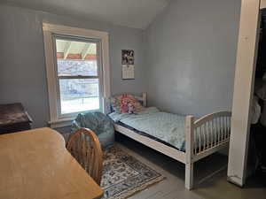 Bedroom featuring vaulted ceiling and wood floors