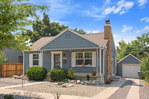 View of front of home featuring a garage, a porch, and an outdoor structure