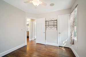 Unfurnished bedroom featuring dark hardwood / wood-style floors and ceiling fan