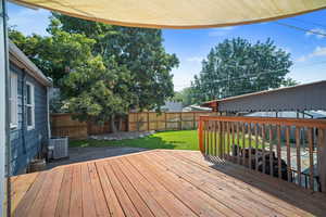 Wooden terrace with central air condition unit and a lawn