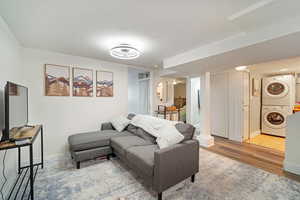 Living room featuring light hardwood / wood-style floors and stacked washer / drying machine