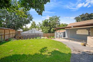 View of yard featuring a patio and a storage unit