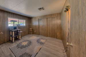 Interior space featuring hardwood / wood-style floors and wooden walls