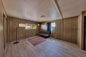 Unfurnished room featuring hardwood / wood-style flooring and wood walls