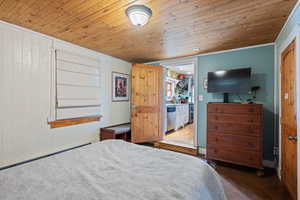 Bedroom with wood-type flooring, baseboard heating, and wood ceiling