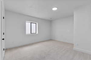 Carpeted empty room featuring a textured ceiling