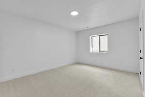 Carpeted empty room featuring a textured ceiling