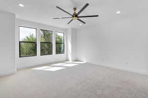 Carpeted spare room with ceiling fan