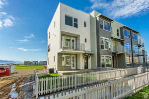 Rear view of house featuring a balcony and central AC unit