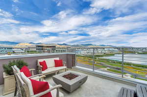 View of patio featuring a mountain view, a balcony, and a fire pit