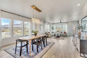 Dining area with a healthy amount of sunlight, ceiling fan, and light wood-type flooring