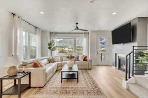 Living room featuring a healthy amount of sunlight, ceiling fan, and light hardwood / wood-style floors