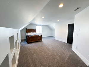 Carpeted bedroom featuring lofted ceiling