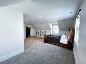 Carpeted bedroom featuring vaulted ceiling