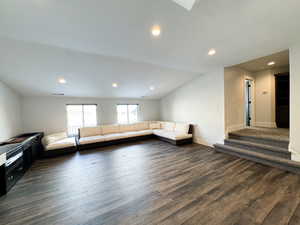 Unfurnished living room with dark hardwood / wood-style floors and lofted ceiling