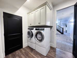 Laundry room featuring cabinets, dark carpet, and washer and clothes dryer