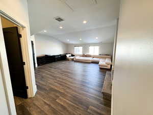 Unfurnished living room with dark hardwood / wood-style flooring and lofted ceiling