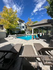 View of swimming pool with a diving board and a patio