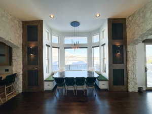 Dining space with an inviting chandelier, dark wood-type flooring, and a wealth of natural light