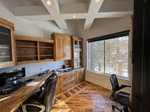 Office area featuring built in desk and coffered ceiling