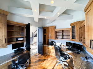 Office featuring light hardwood / wood-style flooring, coffered ceiling, and built in desk