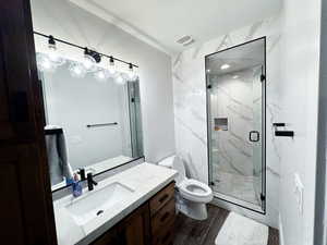 Bathroom with vanity, toilet, wood-type flooring, and walk in shower