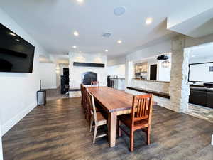 Dining area featuring a fireplace and dark wood-type flooring