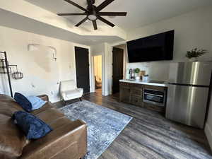 Living room with dark hardwood / wood-style flooring, sink, and ceiling fan