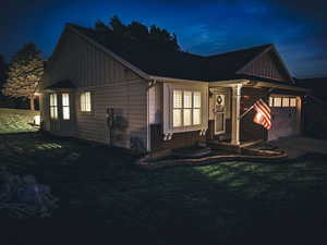 View of front of home with a garage and a lawn